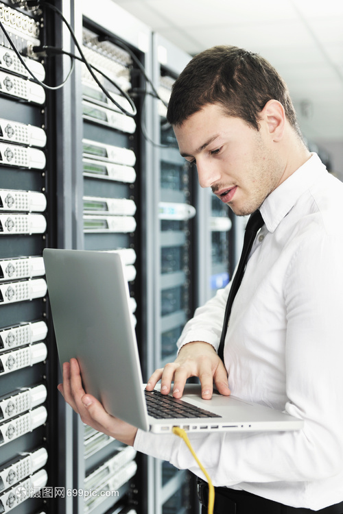 輕的IT工程師與商務(wù)人員 現(xiàn)代鋁制筆記本電腦與網(wǎng)絡(luò)服務(wù)器機房的融合